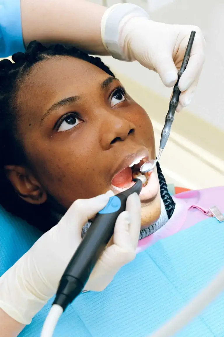 Young woman having her teeth cleaned in the dental chair.