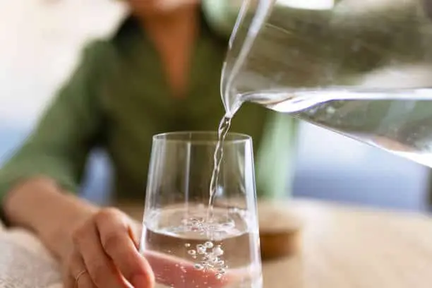 Water being poured from a jug into a glass.