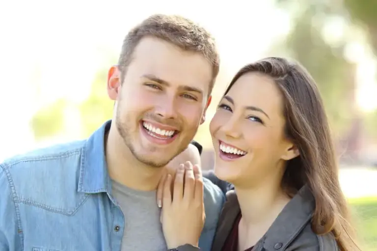 Young couple smiling together outdoors.