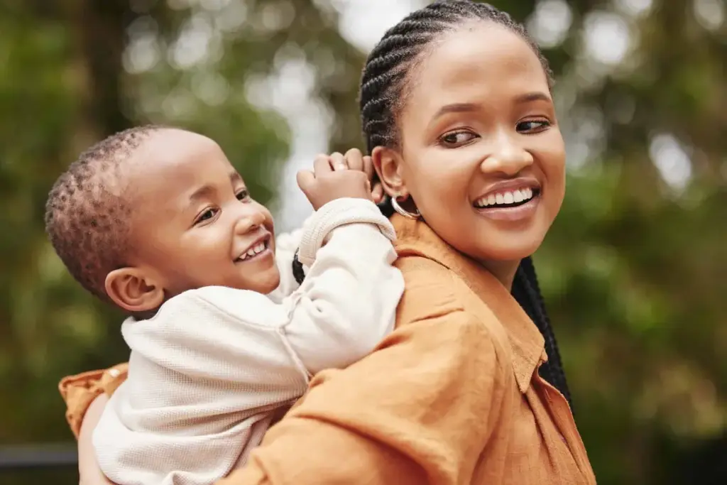 A young mother holding her small child