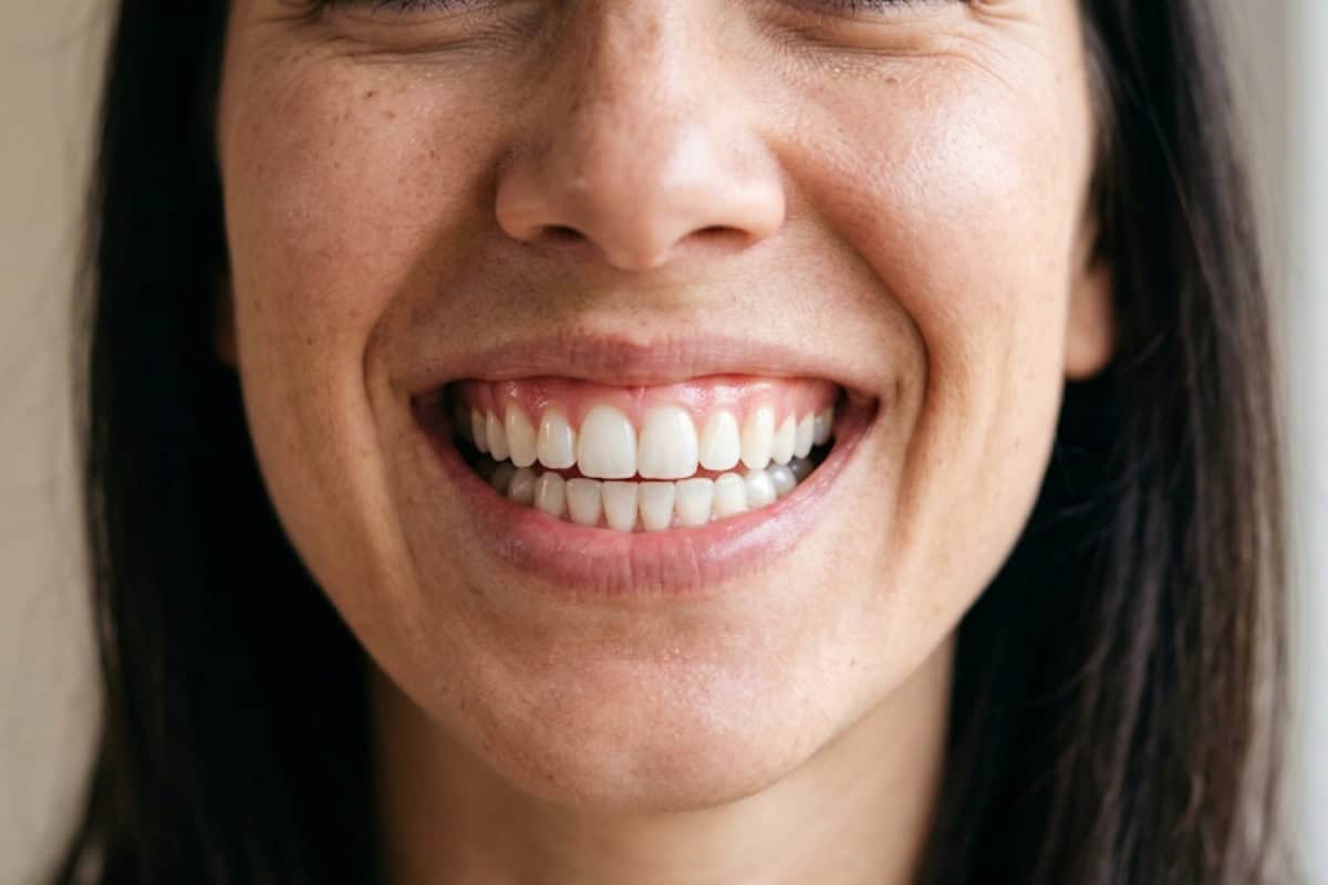 Close-up of a person smiling, showing clean white teeth and pink lips