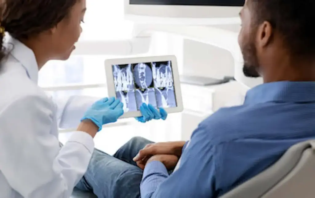 A clinician showing X-ray images on a tablet to a patient